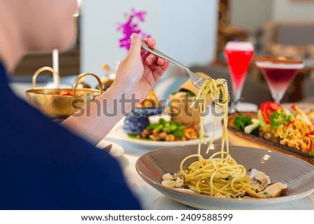 pasta,Close-up of man serving pasta to his friends during lunch in dining room.