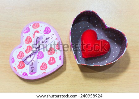 Valentines Day gift box and rose with heart on wooden plates. Sweet holiday background