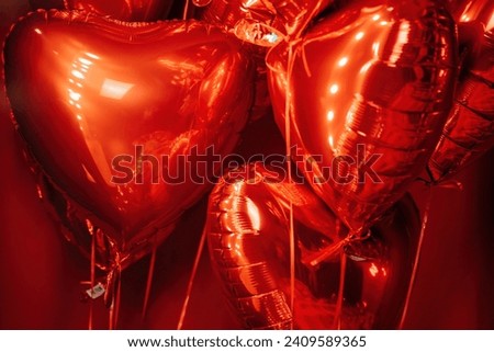 Extravagant glamour background with red foil heart air balloons for love party. Beautiful romantic burlesque room place for st valentines holiday illuminated vanity makeup mirror muffled light Royalty-Free Stock Photo #2409589365