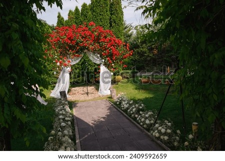 Wedding white arch with red roses. Beautiful garden wedding concept. High quality photo