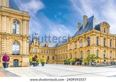 Amiens City hall Hotel de ville is a town hall neo-classical architecture style stone brick building with French flag in Amiens old historical city centre, Somme department, Hauts-de-France Region Royalty-Free Stock Photo #2409593557
