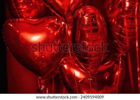 Extravagant glamour background with red foil heart air balloons for love party. Beautiful romantic burlesque room place for st valentines holiday illuminated vanity makeup mirror muffled light Royalty-Free Stock Photo #2409594009