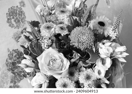 Black and white photograph of a flower arrangement with roses, chrysanthemums.  Floral bouquet.