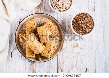 Sweet dessert halva from sunflower seeds with flax seeds on a plate top view