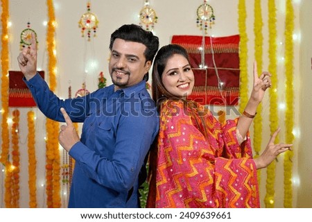 happy couple celebrating Lohri with dance and gajak.