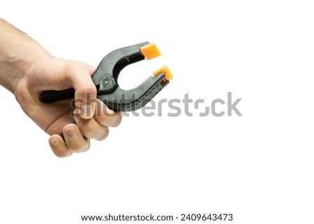 Male hand holding plastic string clamp tool isolated on white background
