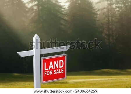 LAND FOR SALE SIGN on empty meadow - Real estate conceptual image