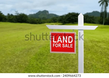 land for sale plate sign, green lawn background