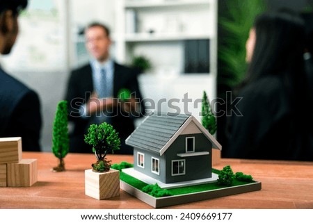 Model showcase eco house and housing business concept while business people on meeting in blur background discussing environmental friendly construction as ideal of sustainability. Quaint Royalty-Free Stock Photo #2409669177