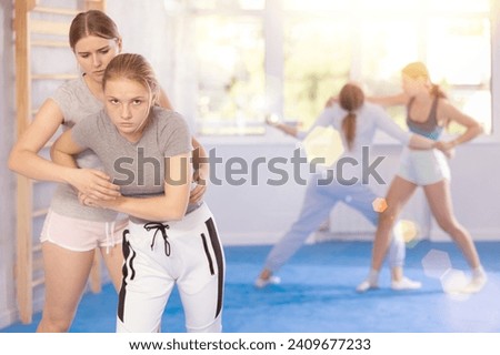 Girl and woman athletes practice self-defense wrestling. Training at Academy of Martial Arts martial arts hand-to-hand combat.