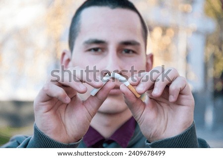 Handsome young happy man with broken cigarette. No more garbage in my lungs. Stop smoking concept. Royalty-Free Stock Photo #2409678499