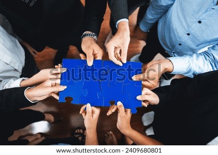Top view multiethnic business people holding jigsaw pieces and merge them together as effective solution solving teamwork, shared vision and common goal combining diverse talent. Meticulous Royalty-Free Stock Photo #2409680801