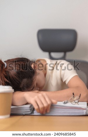 Stressed Asian woman having Tired and Sleepy while working, female businesswoman having headache at office, Exhausted woman with documents folder stack at home late night. Overworked and Overtime Royalty-Free Stock Photo #2409685845