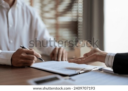 Man signing signature on contract after listening house insurance data from real estate agent woman.