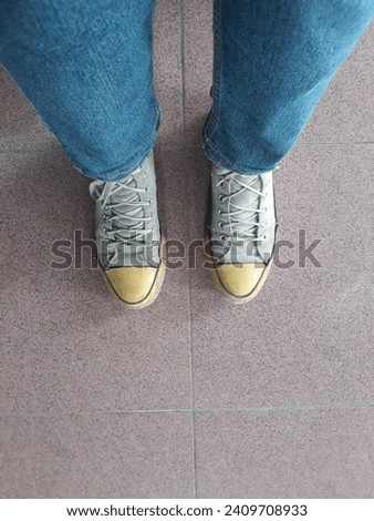 Photo from top to bottom, with both feet wearing shoes