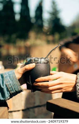 Holding the gourd cup of yerba mate tea Royalty-Free Stock Photo #2409719379