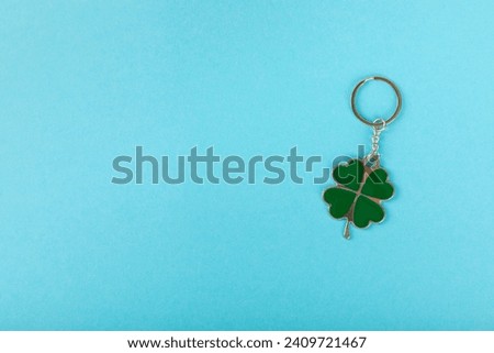 Clover keychain with key ring  on a colored background. Concepts for real estate and moving home or renting property. Buying a property. Mock-up keychain.Copy space.