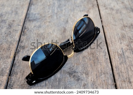 Fashionable and stylish black sunglasses on dirty old wooden background, eye wear for fashion and protecting the eyes from the sun