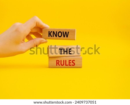 Know the rules symbol. Wooden blocks with words Know the rules. Beautiful yellow background. Businessman hand. Business and Know the rules concept. Copy space.