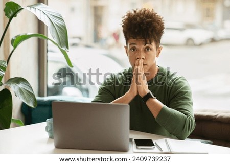 Portrait of pensive young black guy entrepreneur working at cafe, sitting at table, using gadgets laptop and smartphone, copy space. Millennials lifestyle, career, business success