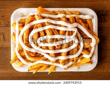 Mayo fries with masala or potato chips loaded with mayonnaise served in dish isolated on wooden background top view of indian spices and pakistani food Royalty-Free Stock Photo #2409743915