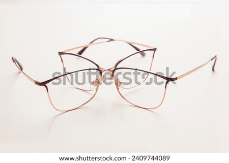 Two stylish gold eyeglasses isolated on white background perspective view