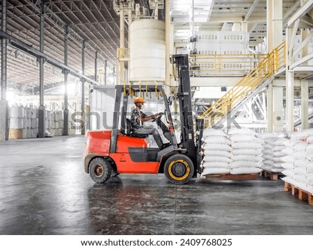 Forklift loader loading pallet of rice bag cargo on a forklift in a warehouse. Rice handling at warehouse for export. Royalty-Free Stock Photo #2409768025