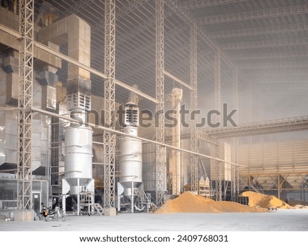 Rice milling factory interior, paddy drying machine and loading area. Post-harvest processing of paddy rice for export. Royalty-Free Stock Photo #2409768031