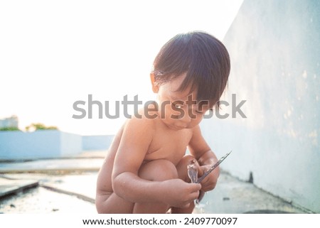 Little preschool happy boy take shower outdoor in basin toddler boy