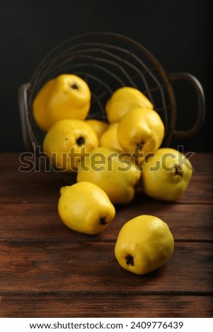 Delicious ripe quinces on wooden table against black background