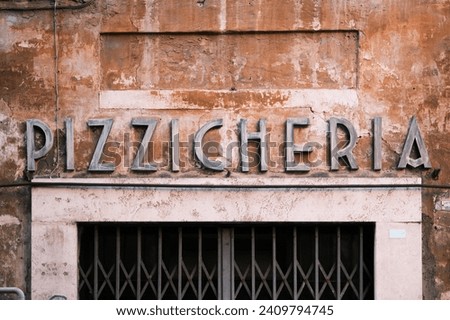 The vintage signage of 'Pizzicheria' etched onto the weathered facade of a Roman building speaks volumes of the city's culinary traditions and the timeless charm that pervades the streets of Rome.
