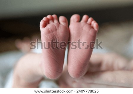 Details of the foot of a one month old baby, female. Photo depicts details of the newborn's feet and toes.
