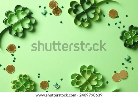 Frame of St Patrick's Day paper cut clover and gold coins on green background
