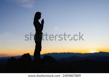 Silhouette of The girl  prayed  in the mountains to think of a loving God, we praise God.