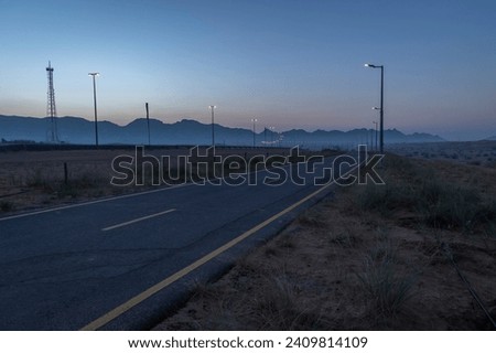 Breathtaking view of golden hour sunrise from Dubai Maleha desert with huge mountains in the background.