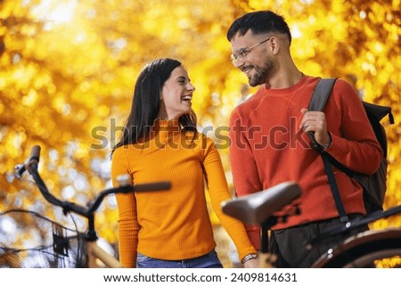 Young couple in love looking at each other on a sunny autumn day
