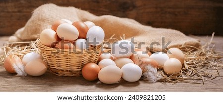 basket of colorful fresh eggs on wooden background Royalty-Free Stock Photo #2409821205