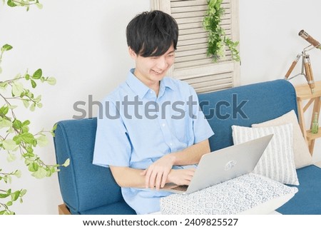 Asian man using the laptop at the living room