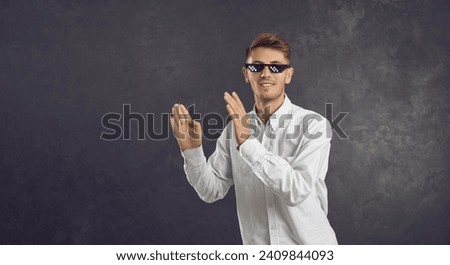 Happy man in thug life glasses dancing isolated on text copy space background. Portrait of cheerful positive young guy in meme sunglasses having fun. College student in funny specs vibing to music
