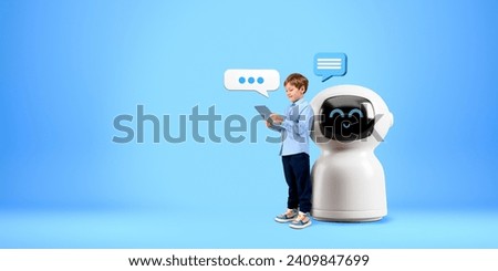 Child using tablet, standing full length near cartoon AI chat bot, speech bubbles on copy space empty blue background. Concept of virtual assistant, technology and machine learning