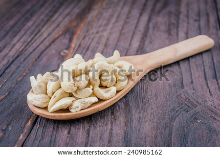 Cashew on spoon on wooden background - vintage effect style pictures