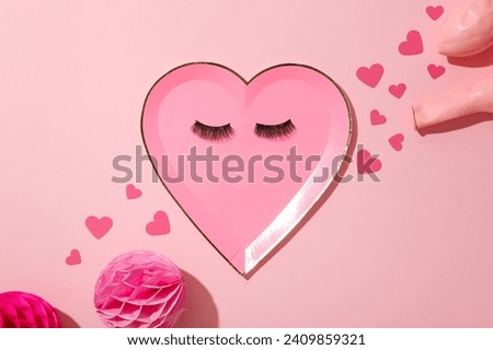 Flat lay plate in the shape of a heart on a pink background.