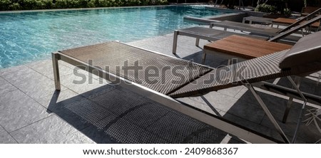 Picture of a sun bed chair on the edge of a hotel or resort rooftop swimming pool.