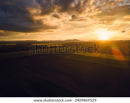 Aerial view of meadows, forest during sunset.