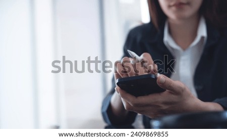 Close up of businesswoman using mobile smart phone and digital tablet computer at office. Asian business woman hand holding smartphone, connecting the internet, online working, corporate business Royalty-Free Stock Photo #2409869855