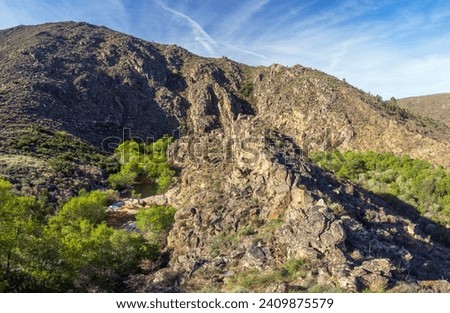 View over a rock formation in the Mondego river valley, in Serra da Estrela in Portugal, from the Alto Mondego viewpoint on the Mondego walkways. Royalty-Free Stock Photo #2409875579