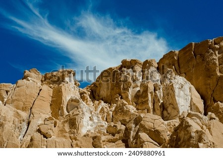 high rocky mountains against the blue sky and white clouds in the desert in Egypt Dahab South Sinai Royalty-Free Stock Photo #2409880961