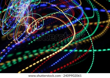 A photograph of vibrant multi-color dotted lights in a long exposure photo. Light painting photography
