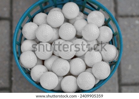 Lots of white golf balls in a bucket. Preparation for the tournament among professionals.