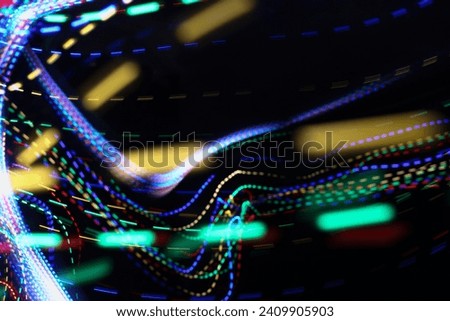 A photograph of vibrant multi-color dotted lights in a long exposure photo against a black background. Light painting photography